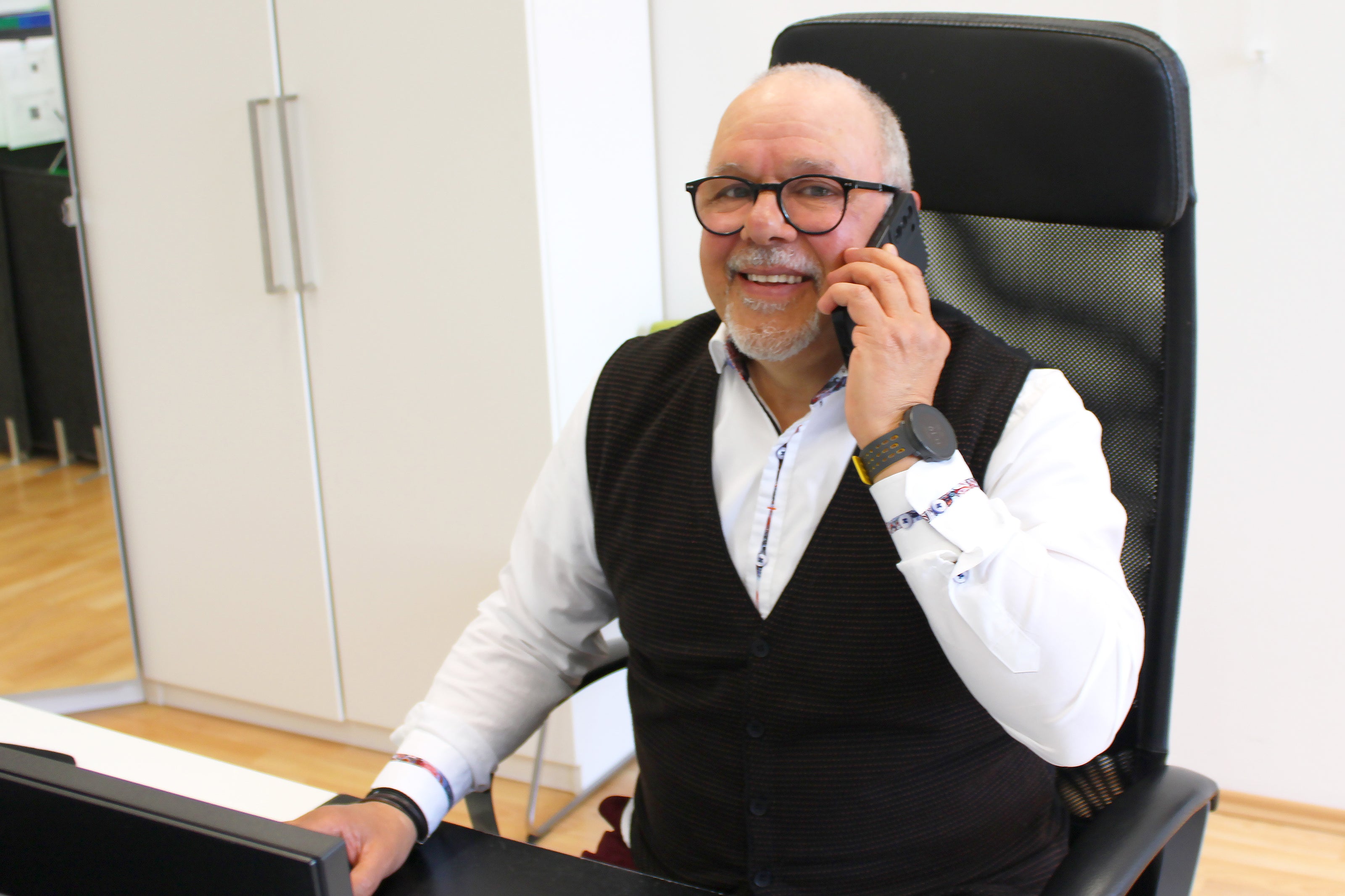 Portrait von Mitarbeiter Alain Pirollo während er gerade am Computer sitzt und telefoniert.