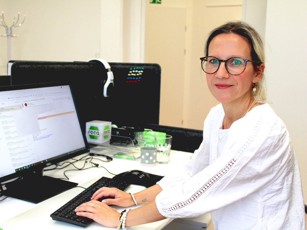 Portrait von Mitarbeiterin Claudia Klawatsch während sie gerade am Computer arbeitet.