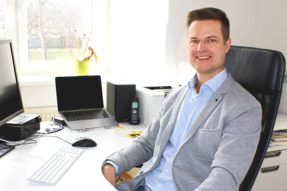 Portrait von Markus Hammer während er gerade vor dem Computer sitzt.