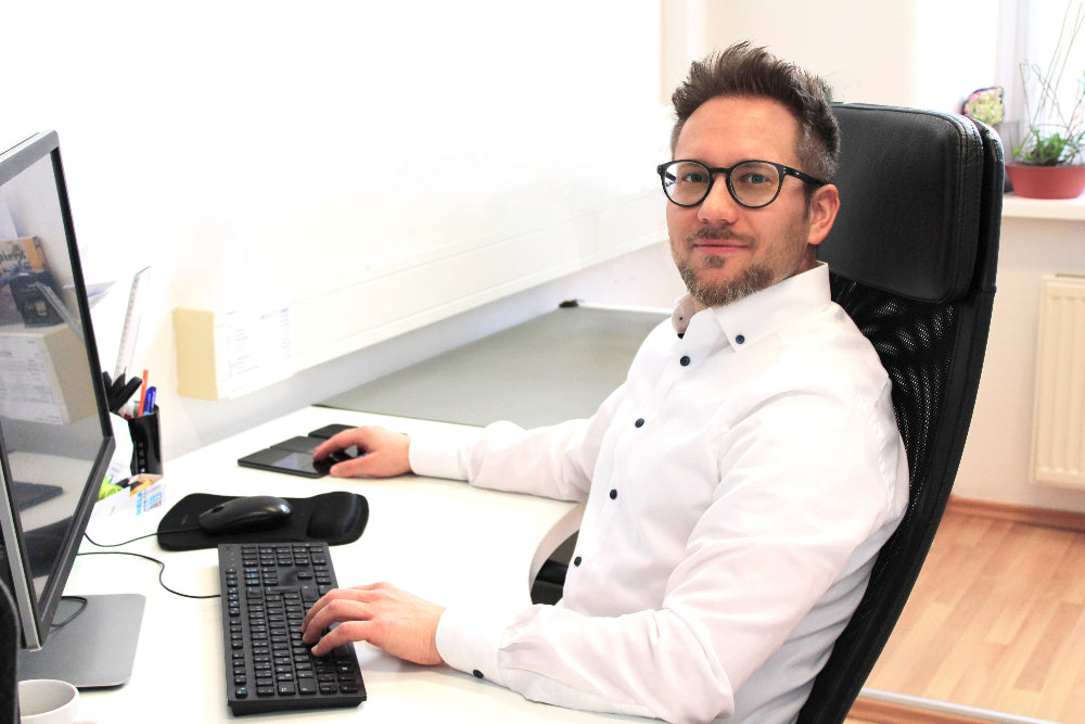 Portrait von Stefan Winkler während er gerade am Computer arbeitet.