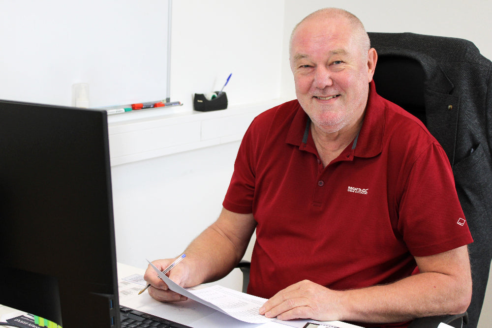 Portrait von Wolfgang Jakob während er gerade am Computer arbeitet.