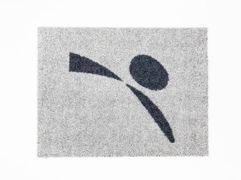 Grey doormat with abstract black figure design, textured surface for pet entryway use